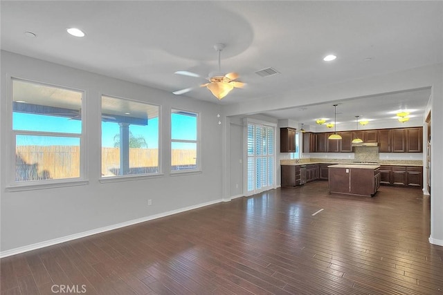 unfurnished living room with ceiling fan and dark wood-type flooring