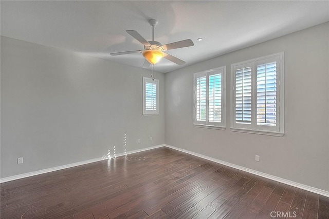 empty room with ceiling fan and dark hardwood / wood-style flooring