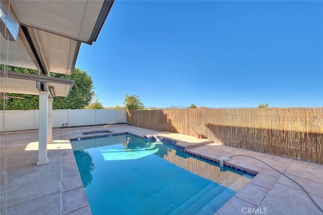 view of swimming pool with a patio area and a hot tub