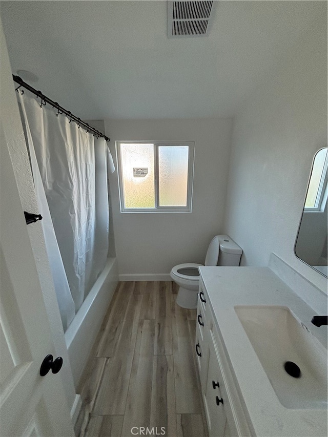 full bathroom with toilet, hardwood / wood-style flooring, vanity, and shower / bathtub combination with curtain