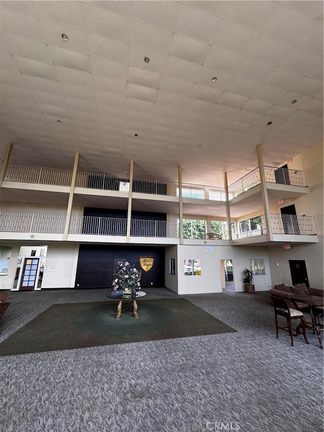 interior space featuring carpet floors and a towering ceiling