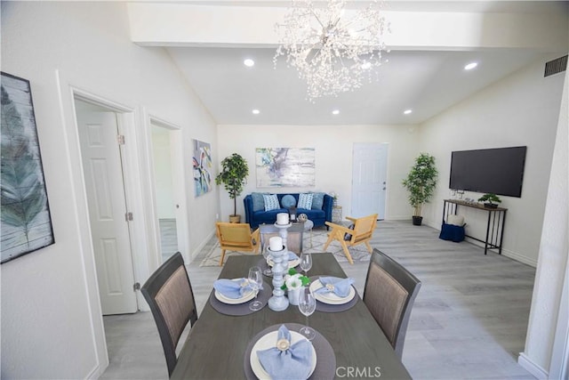 dining space with a notable chandelier, vaulted ceiling, and light wood-type flooring