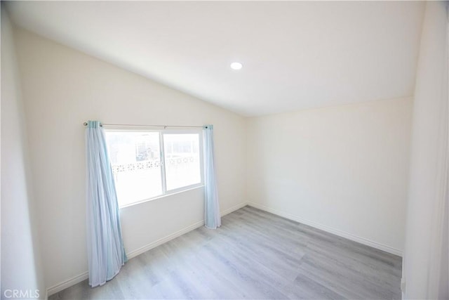 empty room featuring lofted ceiling and light hardwood / wood-style flooring