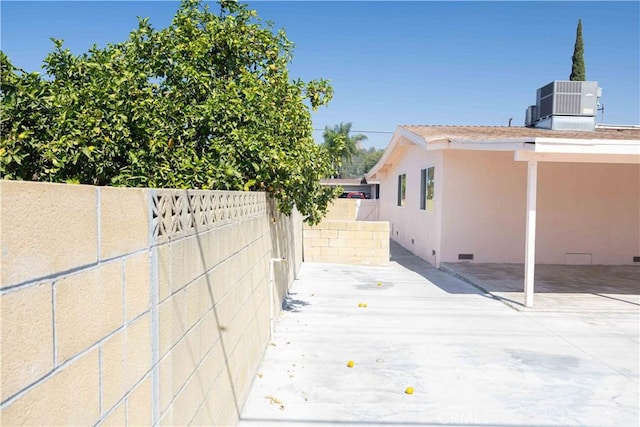 view of side of home with central AC and a patio area