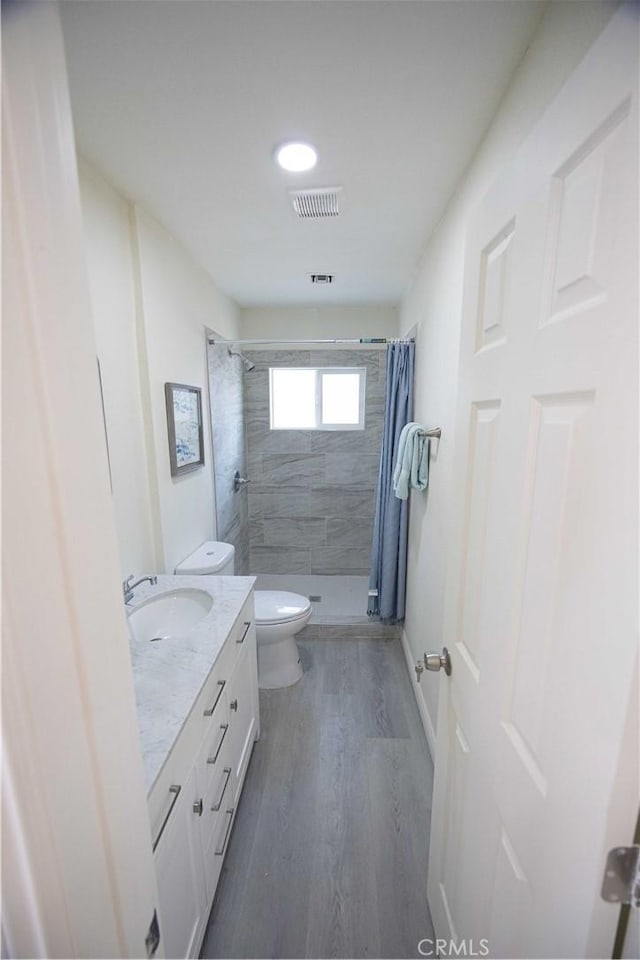 bathroom featuring hardwood / wood-style floors, vanity, toilet, and a shower with shower curtain