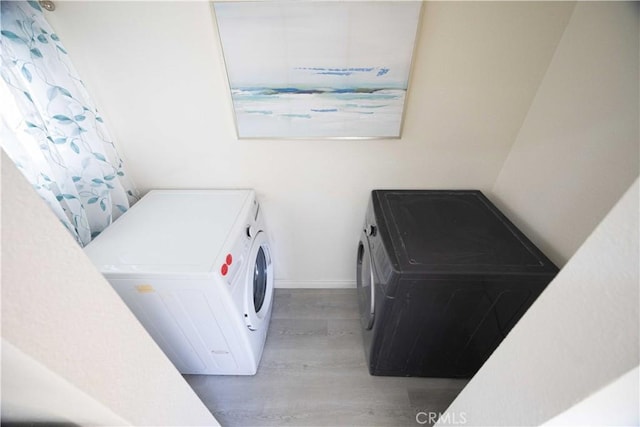 laundry room featuring hardwood / wood-style flooring and separate washer and dryer