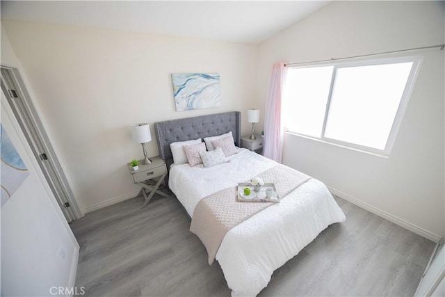 bedroom with light hardwood / wood-style flooring and vaulted ceiling