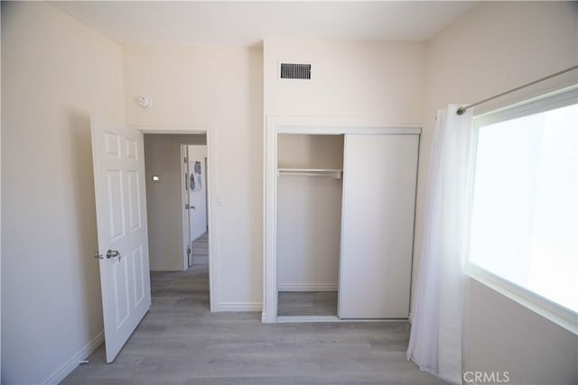 unfurnished bedroom featuring light hardwood / wood-style floors and a closet