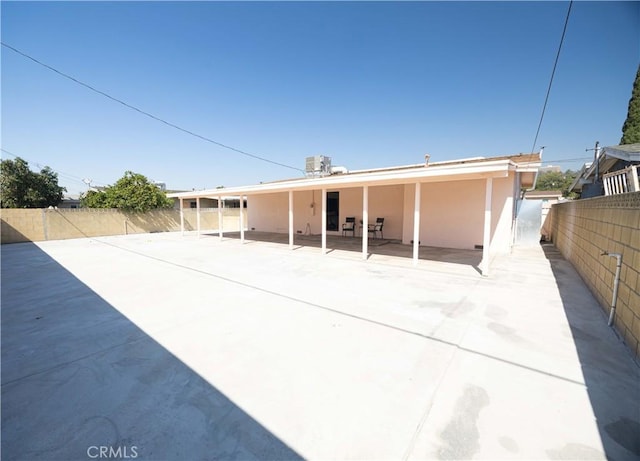 back of property with a patio and central AC