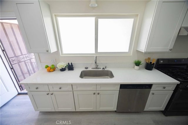 kitchen featuring black gas range, white cabinetry, sink, light hardwood / wood-style flooring, and stainless steel dishwasher