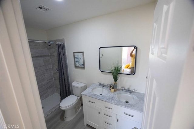 bathroom featuring a shower with shower curtain, hardwood / wood-style floors, vanity, and toilet