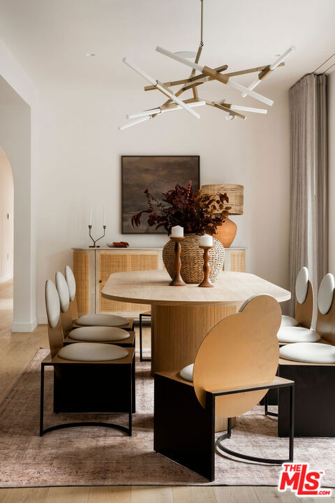 dining area featuring wood-type flooring and an inviting chandelier