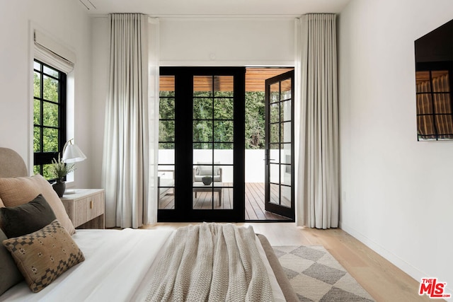 bedroom with light hardwood / wood-style flooring, access to outside, and french doors