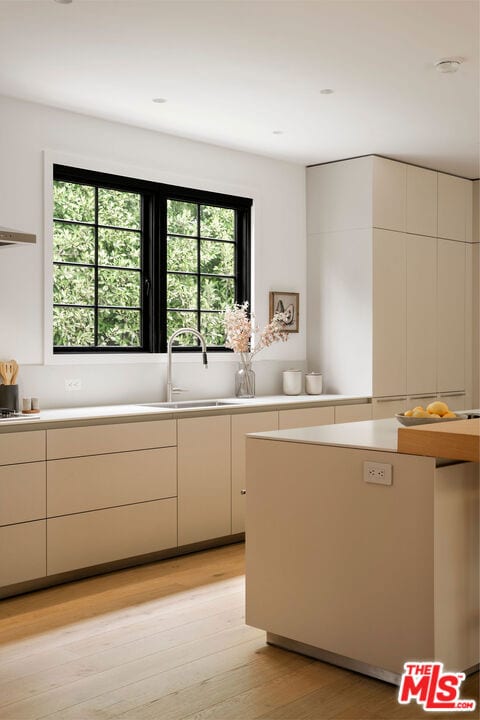 kitchen with stovetop, light wood-type flooring, and sink