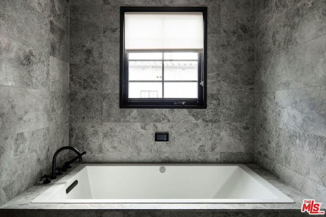 bathroom featuring a relaxing tiled tub