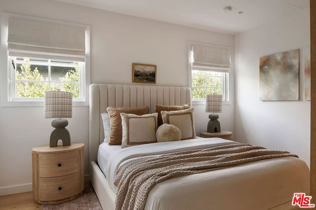 bedroom featuring multiple windows and hardwood / wood-style flooring