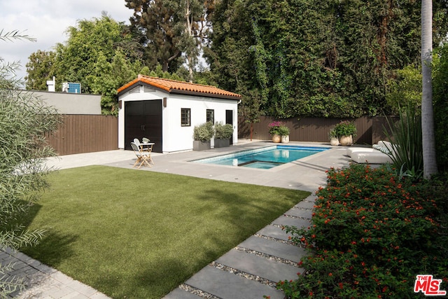 view of swimming pool featuring an outbuilding, a yard, and a patio