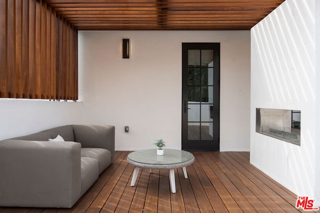 living room featuring wood-type flooring and wooden ceiling