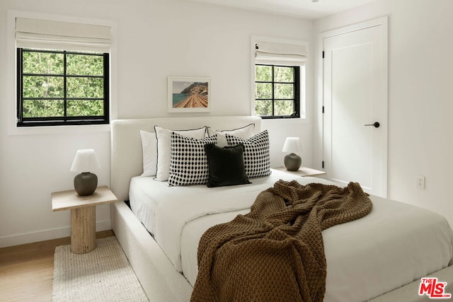 bedroom featuring hardwood / wood-style floors and multiple windows