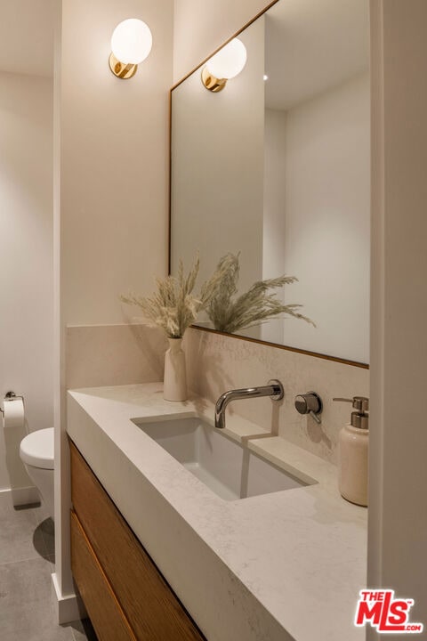 bathroom featuring tile patterned floors, vanity, and toilet