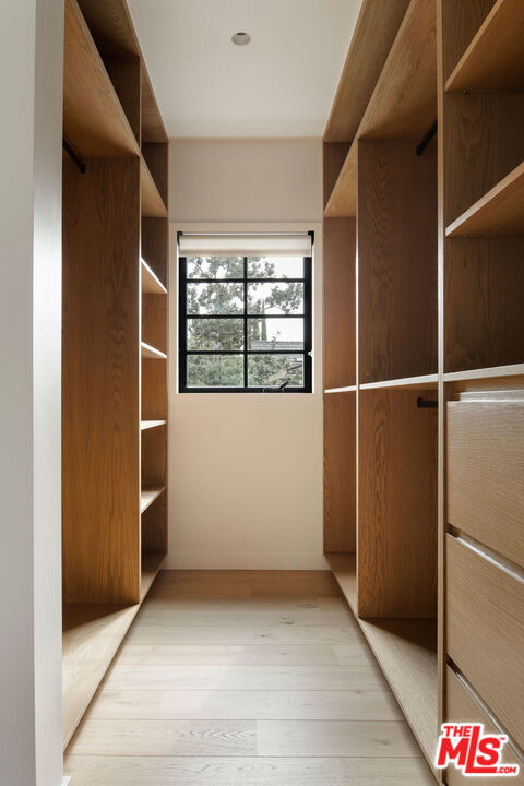 spacious closet featuring light hardwood / wood-style floors