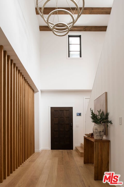 entrance foyer with hardwood / wood-style floors and a notable chandelier