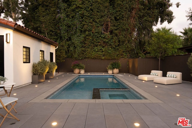 view of swimming pool featuring an in ground hot tub and a patio