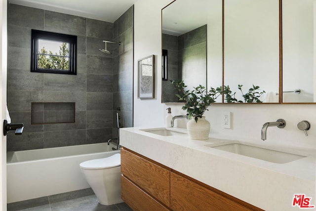 full bathroom featuring tile patterned floors, vanity, tiled shower / bath combo, and toilet