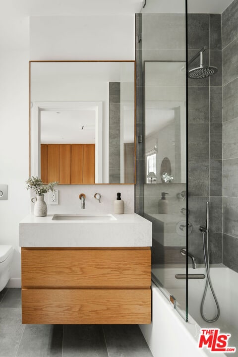 full bathroom featuring shower / bath combination with glass door, vanity, and toilet