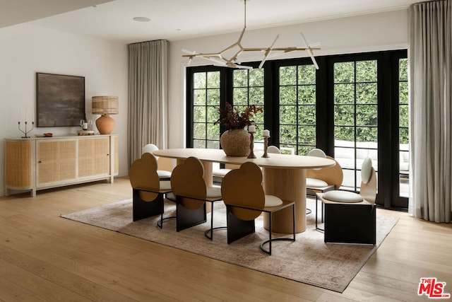 dining space featuring crown molding, french doors, a notable chandelier, and light wood-type flooring