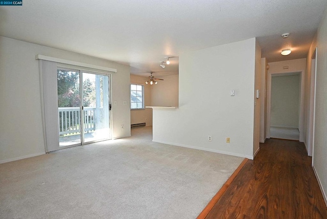 unfurnished room featuring hardwood / wood-style floors, a baseboard heating unit, and ceiling fan