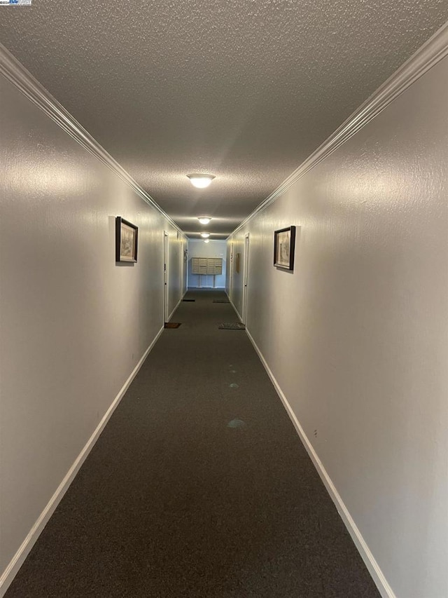 hallway featuring a textured ceiling and ornamental molding