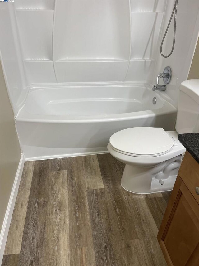 full bathroom featuring toilet, tub / shower combination, hardwood / wood-style flooring, and vanity