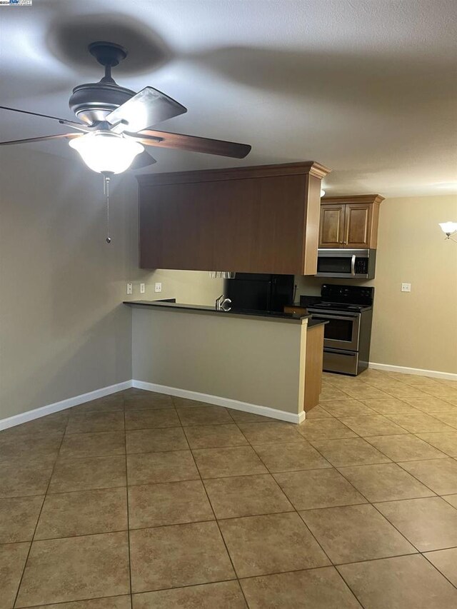 kitchen featuring ceiling fan, light tile patterned floors, and appliances with stainless steel finishes