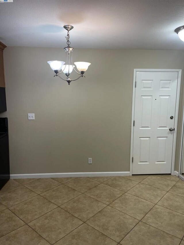 unfurnished dining area featuring a chandelier and tile patterned floors