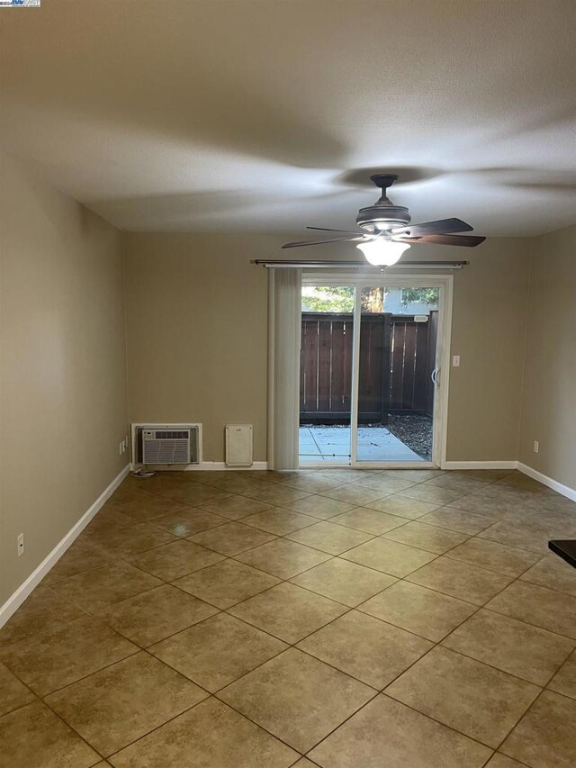 tiled spare room with ceiling fan and a wall mounted air conditioner