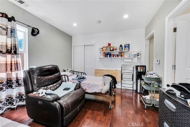 bedroom with dark wood-type flooring and a closet