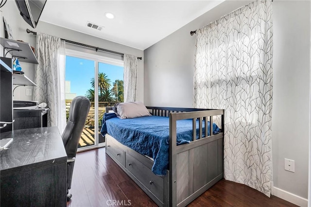 bedroom with dark hardwood / wood-style floors