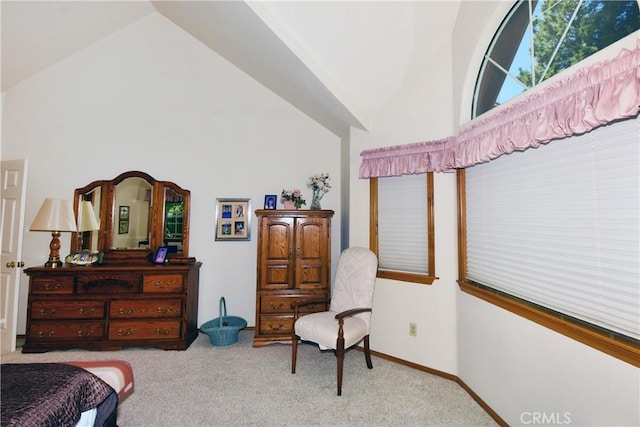 carpeted bedroom with high vaulted ceiling and baseboards