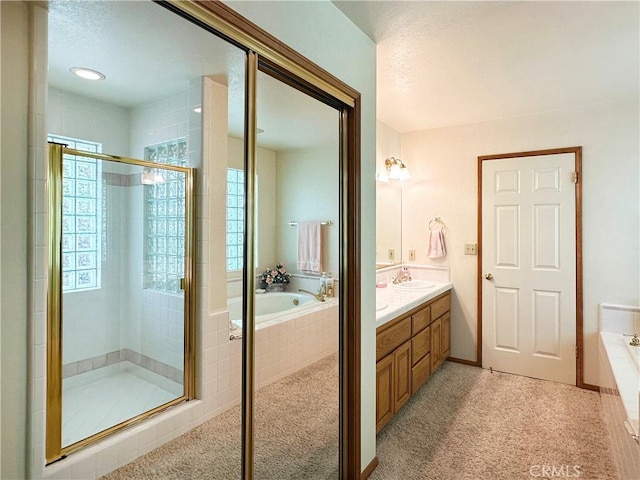 bathroom featuring a wealth of natural light, a sink, a garden tub, and a stall shower