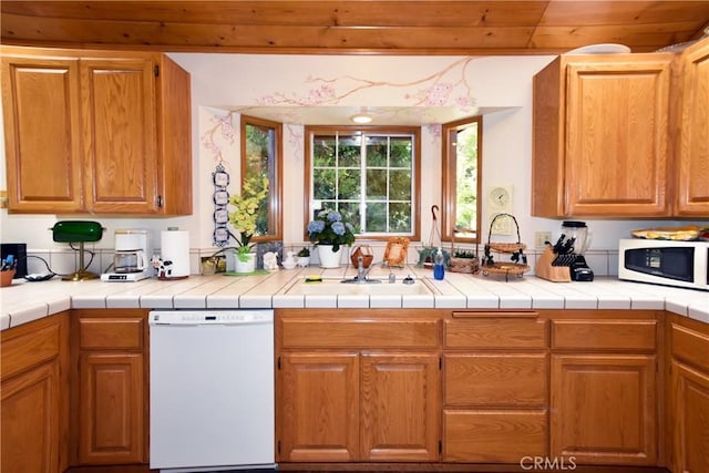 kitchen featuring a sink, wood ceiling, white appliances, and light countertops