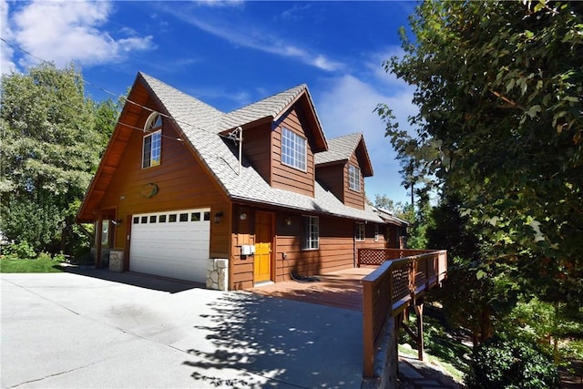27547 W Shore Rd, Lake Arrowhead, CA 92352 - view of front facade with a garage, concrete driveway, stone siding, and roof with shingles