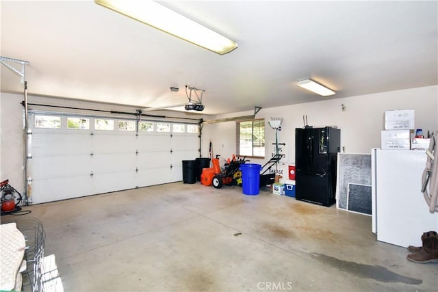 garage featuring a garage door opener and black refrigerator