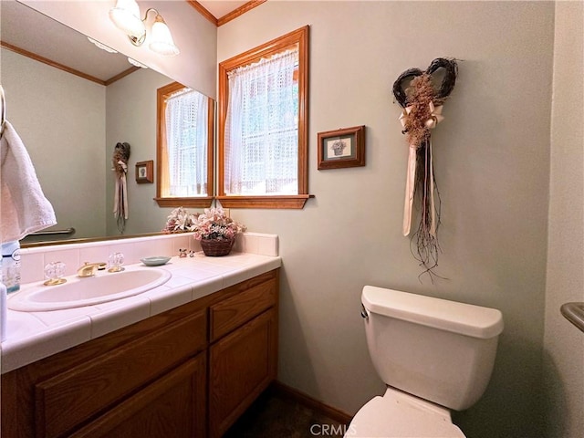 bathroom featuring vanity, toilet, and ornamental molding