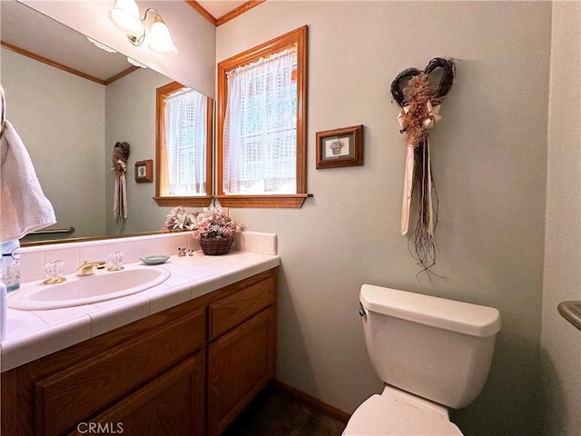 bathroom featuring vanity, ornamental molding, and toilet