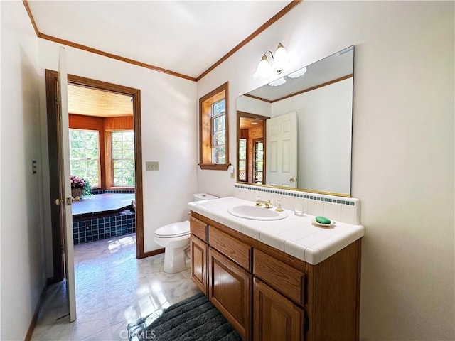 bathroom with vanity, a relaxing tiled tub, crown molding, and toilet