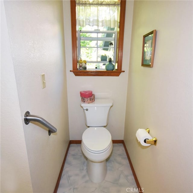 bathroom with baseboards and toilet