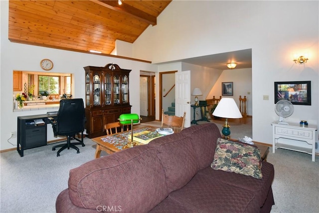 carpeted living area featuring beamed ceiling, wooden ceiling, baseboards, and stairway