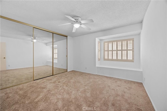 unfurnished bedroom featuring carpet flooring, ceiling fan, a textured ceiling, and a closet