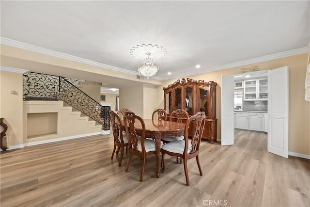 dining space with light hardwood / wood-style flooring, a notable chandelier, and ornamental molding